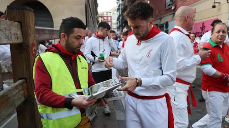 Un corredor compra el periódico a un vendedor ambulante antes de un encierro del año pasado