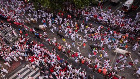 Varias líneas de gente junto al vallado antes del comienzo del primer encierro de San Fermín
