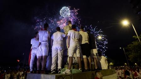 Un grupo de personas subidos en una estructura viendo los fuegos artificiales del día 6 de julio /