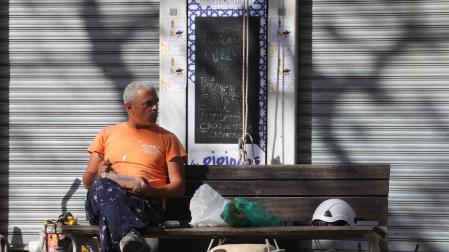 Un trabajador descansa en un banco