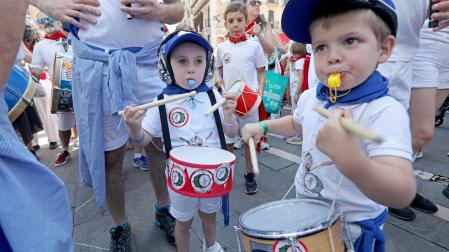 Dos niños hacen vibrar sus tambores y silbatos durante el desfile, pasadas las 12 del mediodía