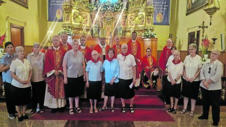 Las hermanas de las Hijas de la Caridad, con un pañuelo rojo junto al arzobispo y los sacerdotes que le acompañaron en la misa