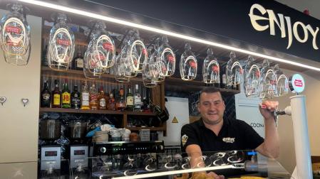 Ángel Dequel Erro, dueño del bar Enjoy en Sarriguren, posa con los cañeros de la barra y pintxos tradicionales
