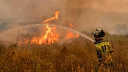 Un bombero trabaja en las labores de extinción del incendio forestal que permanece activo este martes en Monterrei (Ourense)