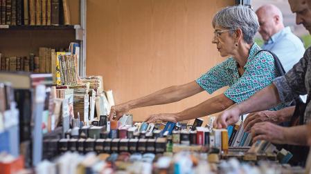 Una mujer mira ejemplares de libros en la Feria del Libro Antiguo y de Ocasión de Pamplona