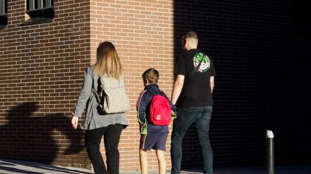 Una pareja lleva a su hijo al colegio en Madrid