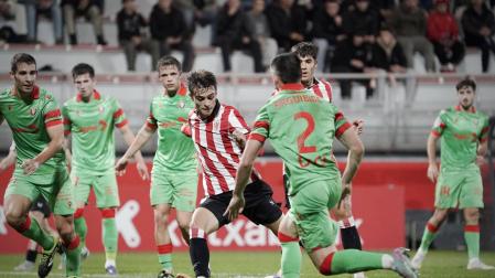 El centrocampista del Bilbao Athletic Lete golpea ante Arguibide y Osambela.