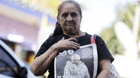 Una mujer sostiene un ejemplar de prensa con la noticia del fallecimiento del técnico de Boca Juniors Miguel Ángel Russo /