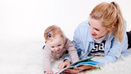 Una madre enseña un libro a su bebé