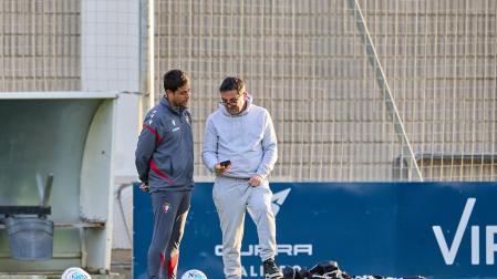 Braulio Vázquez enseña a Alessio Lisci la pantalla de su teléfono móvil al término del entrenamiento de ayer