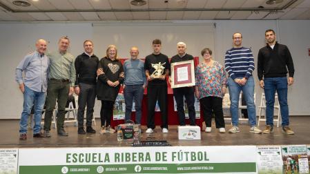 HOMENAJE A AIMAR OROZ El jugador de Osasuna Aimar Oroz, en el centro de la imagen, recibido ayer el premio de la Escuela Ribera de Fútbol. En la foto, de izda. a dcha.: Luis González ‘El Jabonero’, José Luis Sanz, Óscar Bea, Inma Ciriza, José Mª Pastor, Aimar Oroz, Chus Rodríguez, Raquel Paz, Jorge Aguirre, y Uriel Arellano