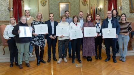Delante, de izda. a dcha., los homenajeados Clara Martínez Lázaro, Marisol Montañés Bernal, Reme Vidondo Moreno, María José Varea Piñeiro, Isabel Martínez Aguado, y Jesús Gómez Martínez. Detrás, también de izda. a dcha., los ediles Anichu Agüera Angulo, Irune García García, Zeus Pérez Pérez, Martín López Villacastín, Alejandro Toquero Gil (alcalde), Laura Casanova Sainz-Aja, Reyes Carmona Blasco, y Eva Eliceche León