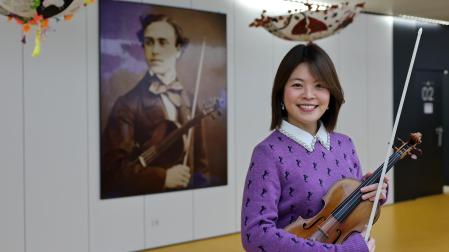 Jiyoon Lee sujeta su violín en el Conservatorio Profesional de Música Pablo Sarasate, ante una imagen del músico pamplonés