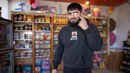 Nacho Cerreduela Pérez señala su ojo, cubierto por una chuchería de huevo frito, en el interior de su negocio