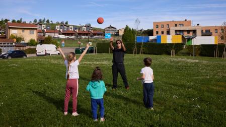 Txikis y adultos juegan en una zona verde de Olloki, mayor población por habitantes de Esteribar