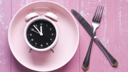 the concept of Healthy Food, alarm clock on plate