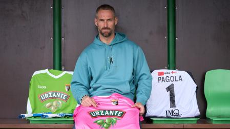 Con tres camisetas del Tudelano, Mikel Pagola posa en la marquesina que tiene como banquillo el campo de Peritos de Villava.