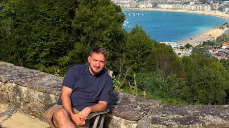 El cocinero Iñaki Andradas posa sentado con la bahía de La Concha de fondo