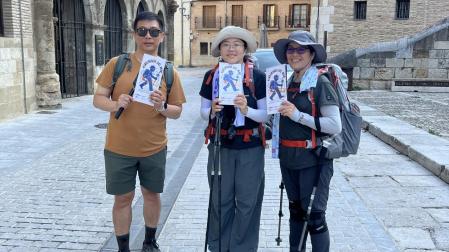 Varios peregrinos posan con el cartel de la campaña en Estella