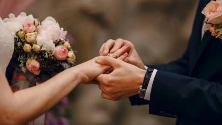 Imagen de una boda en el momento de colocar los anillos