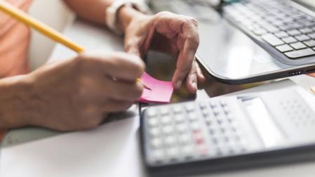 Imagen de una persona manejando documentación y una calculadora