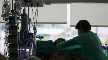 Un médico con un paciente en la UCI del Hospital de la Paz en Madrid.