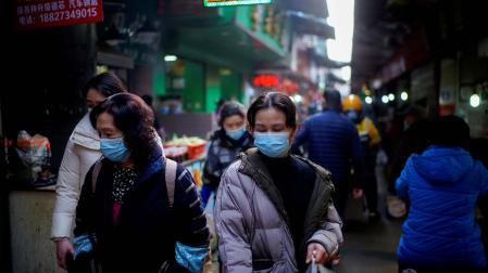Varias personas caminan por las calles de Wuhan