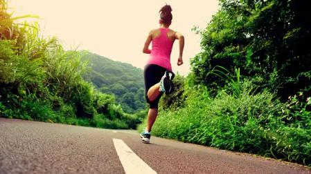 Una mujer, corriendo en una carretera