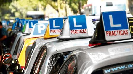 Varios coches de autoescuelas aparcados antes de un examen práctico