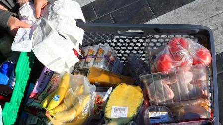 Una persona, con tickets y el carro de la compra recién hecha