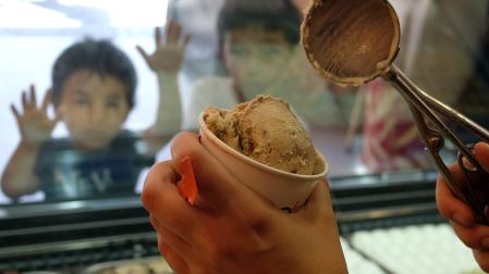 Unos niños esperan con ganas que les sirvan su helado