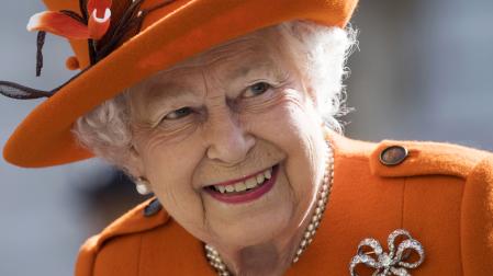 Imagen de la reina Isabel II, vestida con abrigo y sombrero naranja