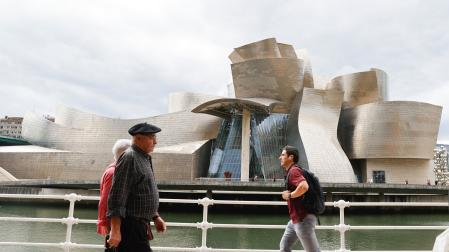 Varias personas pasan ante el Museo Guggenheim de Bilbao, obra del arquitecto Frank Gehry, que este año conmemora su 25 aniversario
