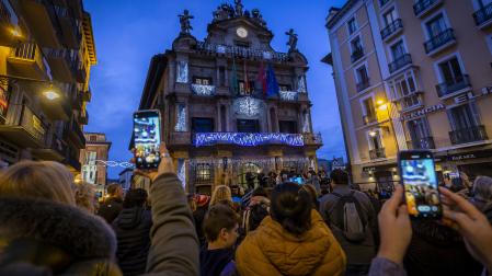 Teléfonos en alto para recoger el encendido de la iluminación navideña en la facgada del Ayuntamiento de Pamplona.