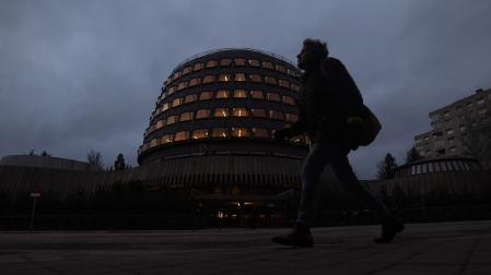 Una persona camina junto al edificio del Tribunal Constitucional, en Madrid