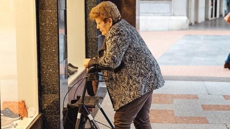 Una pensionista observa un escaparate en Barakaldo, Vizcaya