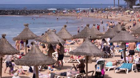 Numerosos turistas disfrutan del buen tiempo este sábado en la playa de El Camisón, en el municipio de Arona, al sur de la isla de Tenerife