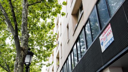 Un cartel de 'En venta' de una inmobiliaria, en un portal del distrito de Embajadores de Madrid