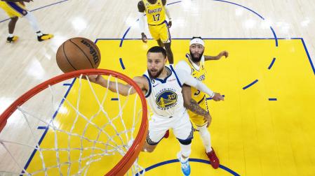 Stephen Curry entra a canasta tras sortear a Anthony Davis durante el encuentro