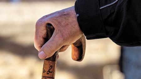 Una persona mayor se apoya en un bastón