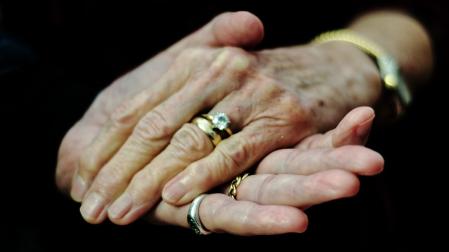 Una pareja de ancianos se agarran la mano