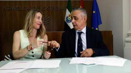 La presidenta del PP de Extremadura, María Guardiola, y el portavoz de Vox en la Asamblea de Extremadura, Ángel Pelayo Gordillo, durante la firma del acuerdo entre PP y Vox para gobernar en coalición Extremadura