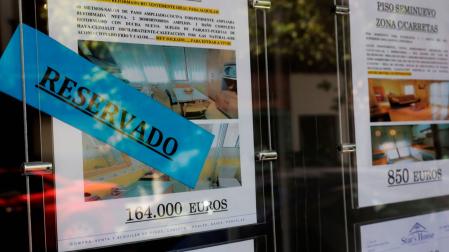 Anuncios de pisos y casas en venta y alquiler en el escaparate de una inmobiliaria, en Madrid