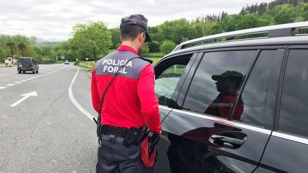 Un agente de la Policía Foral charla con el conductor de un coche, detenido en el arcén