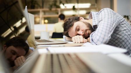 Un hombre dormido en el trabajo después de una noche de insomnio