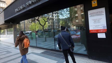 Dos personas pasan junto a la oficina que Hacienda tiene en la calle Esquíroz de Pamplona