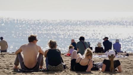 Varias personas disfrutan del buen tiempo en la playa de la Malagueta (Málaga)