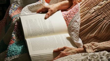 Una persona mayor leyendo un libro