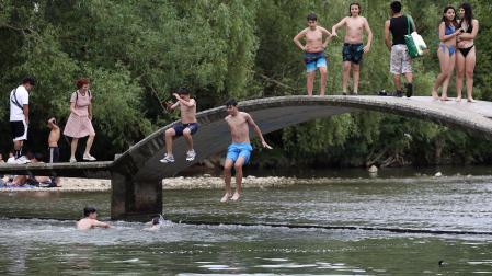 Fotos de los bañistas en el río Arga, junto al Molino de Caparroso, en Pamplona, en una jornada de intenso calor.