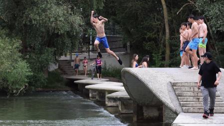 Fotos de los bañistas en el río Arga, junto al Molino de Caparroso, en Pamplona, en una jornada de intenso calor.